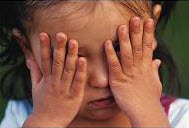 Small child covering their eyes with their hands